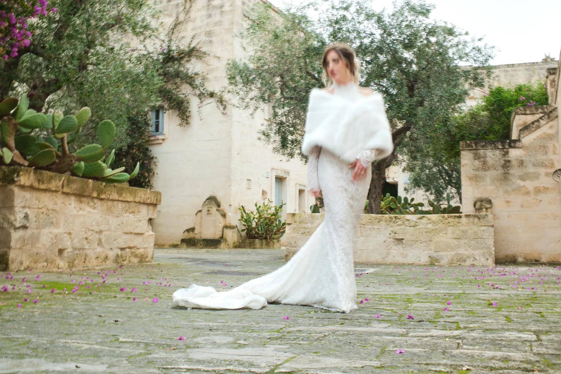 La sposa nella piazzetta in pietra tra ulivi e fichi d'India