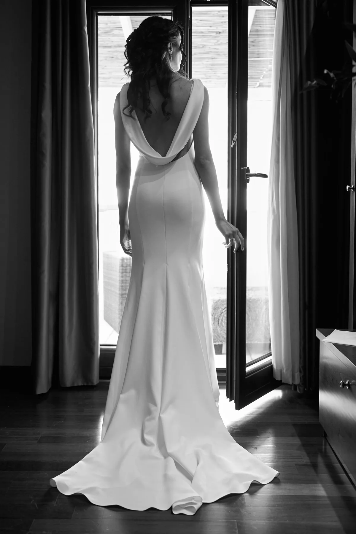 Hanan from behind by the window, in black and white