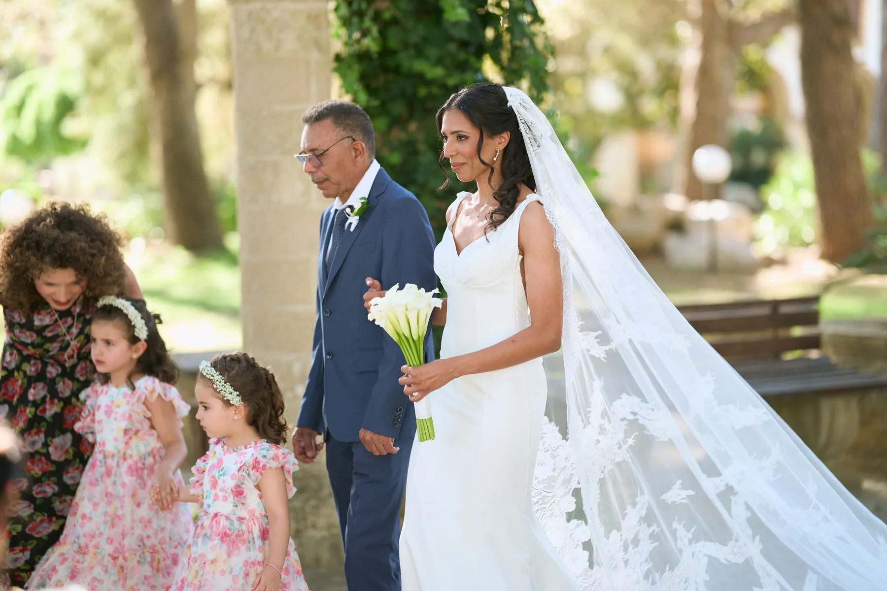 Hanan arriving on her father's arm, with the flower girls