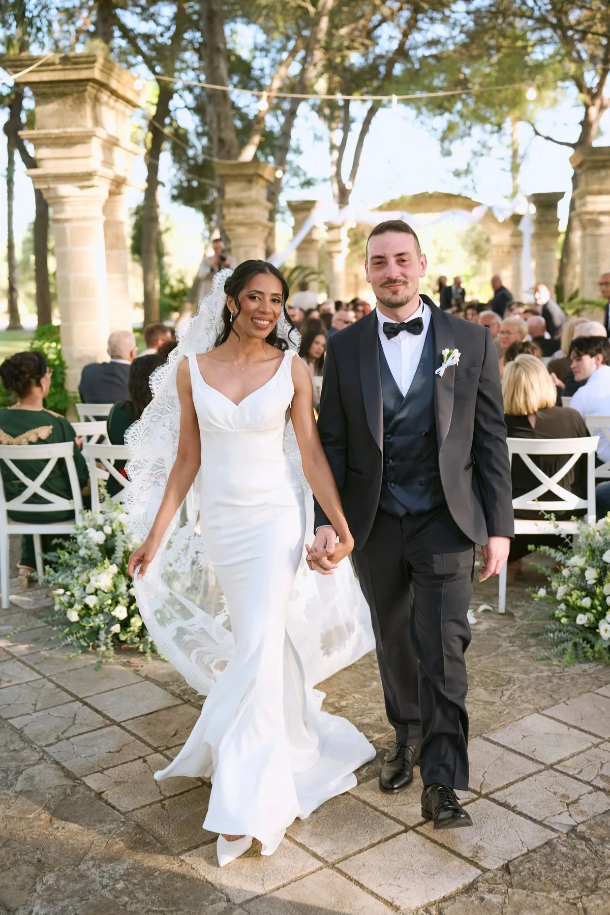Diego and Hanan walking out as a married couple among the guests