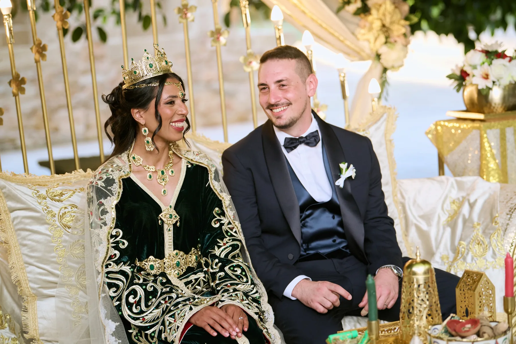 Hanan in her traditional kaftan and crown sitting beside Diego at Masseria Martuccio