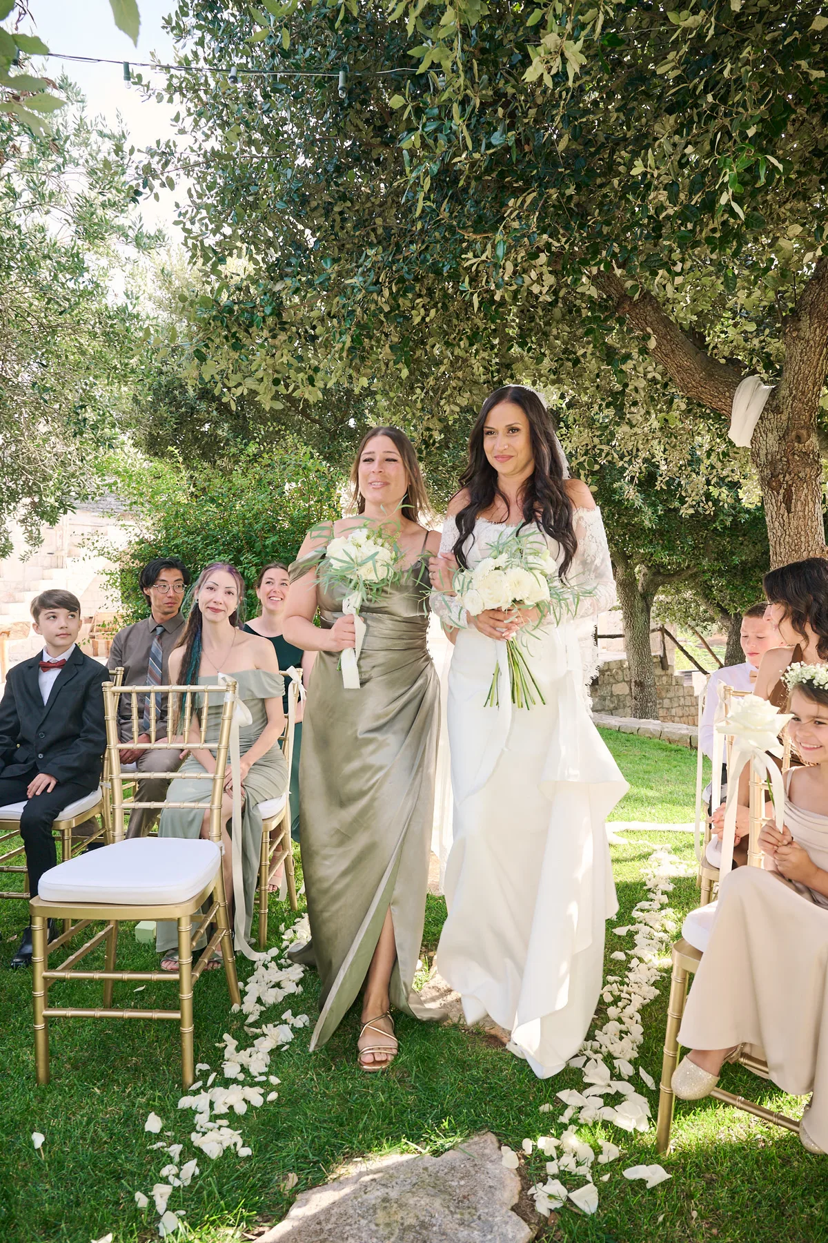 Jenny walking down the aisle under the olive trees