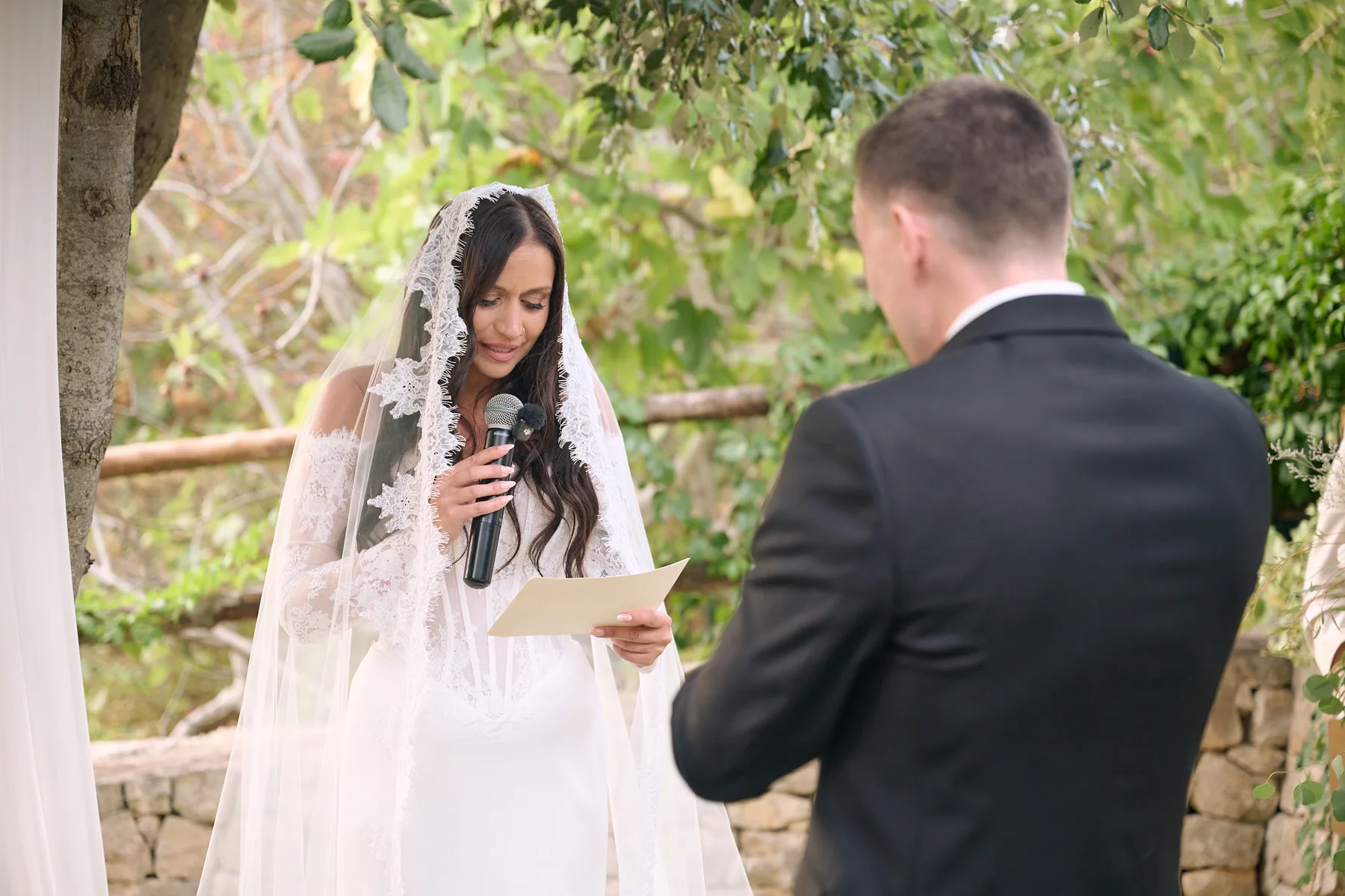 Jenny reading her vows to Brad under the olive tree