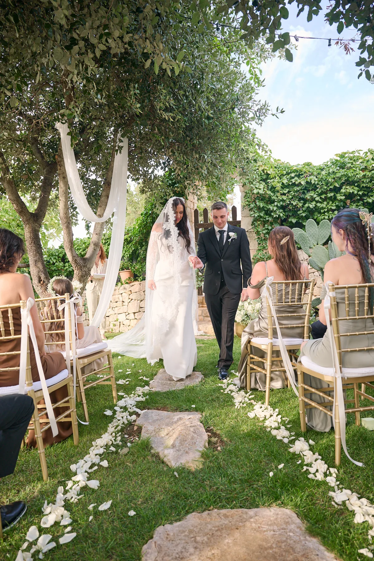 Jenny and Brad walking back down the petal aisle as a married couple