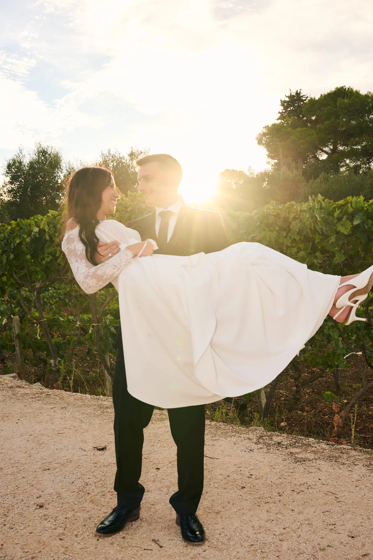Brad lifting Jenny in the vineyard at sunset