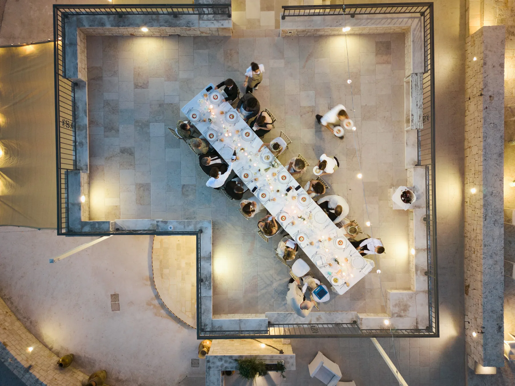 Overhead view of dinner in the lit courtyard