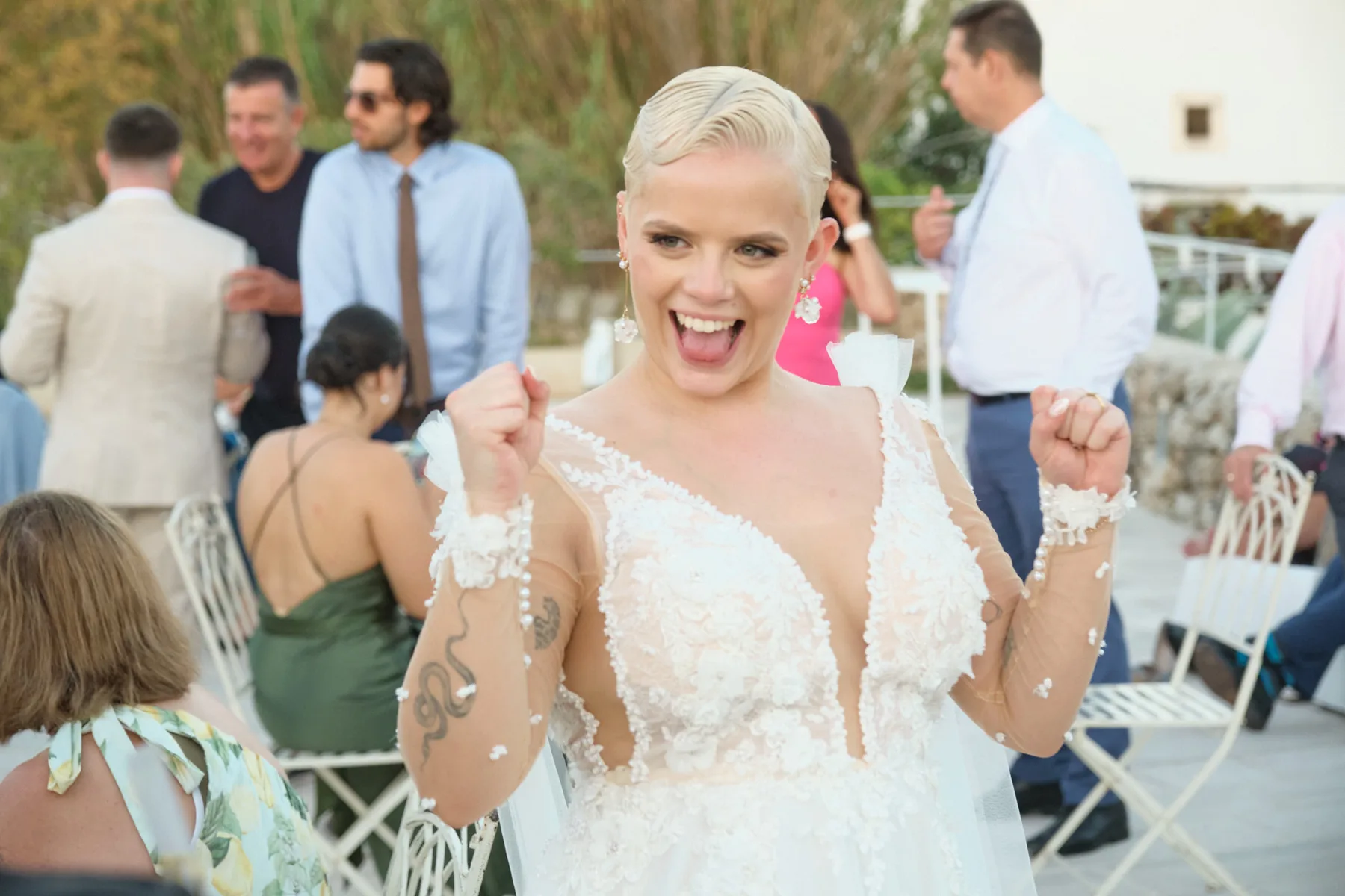 Una sposa esulta felice tra gli ospiti durante il ricevimento all'aperto