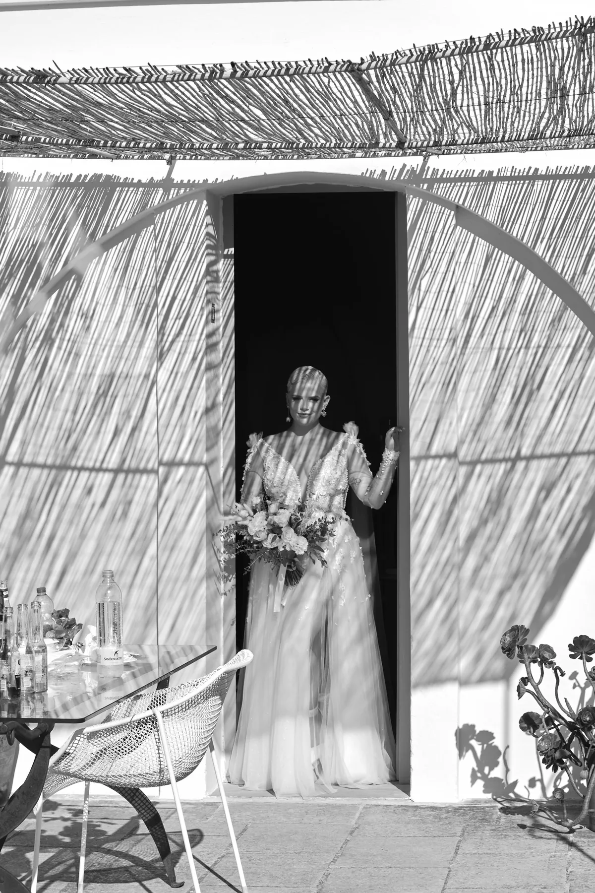 Natasha in her wedding dress at the door, in black and white