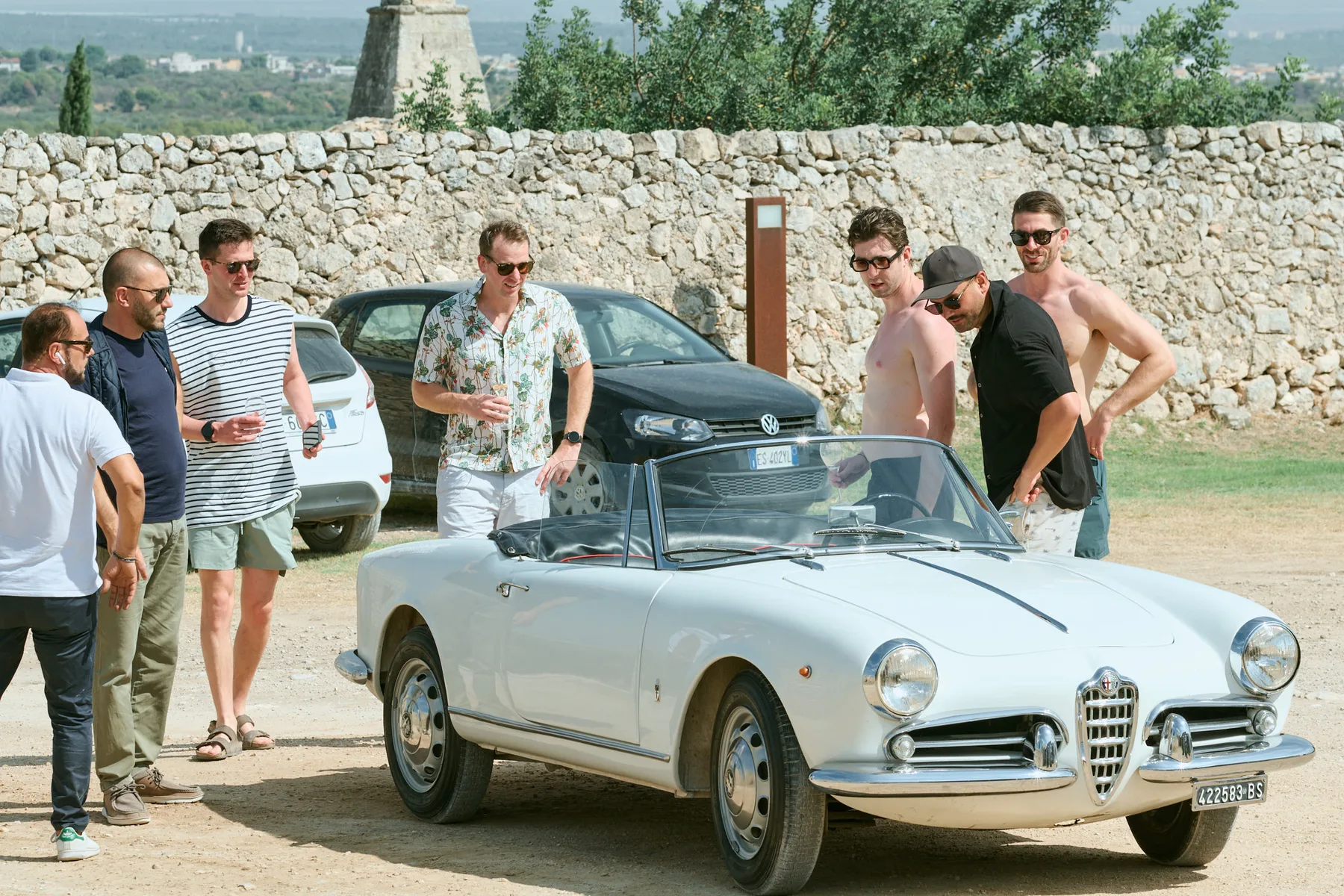 The groom and his friends beside a vintage car