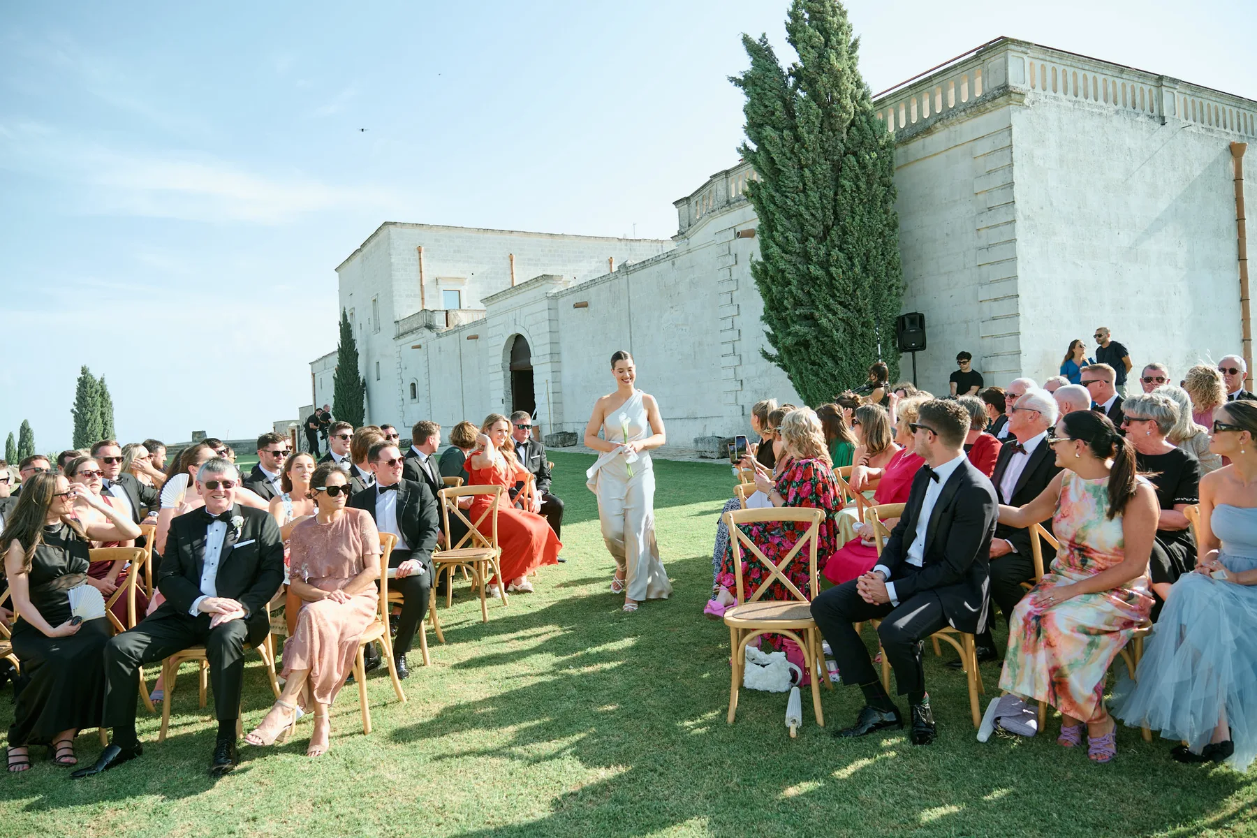 The bride walking across the lawn to the ceremony