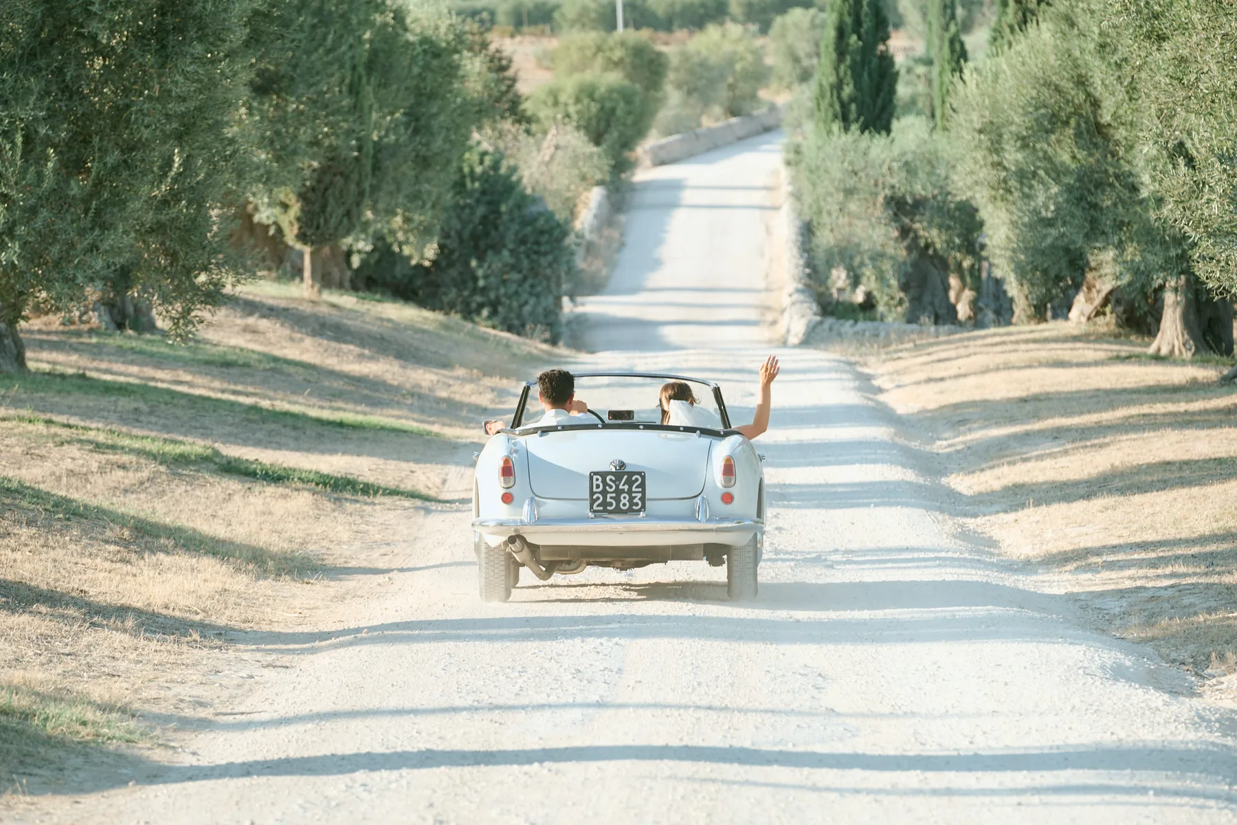 The couple’s vintage car on the olive-lined drive