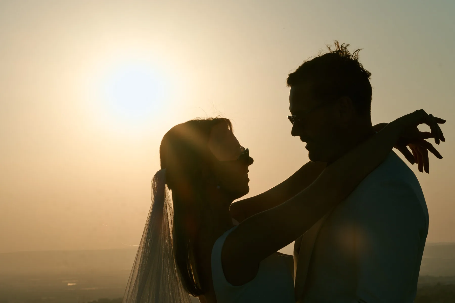 The couple silhouetted at sunset