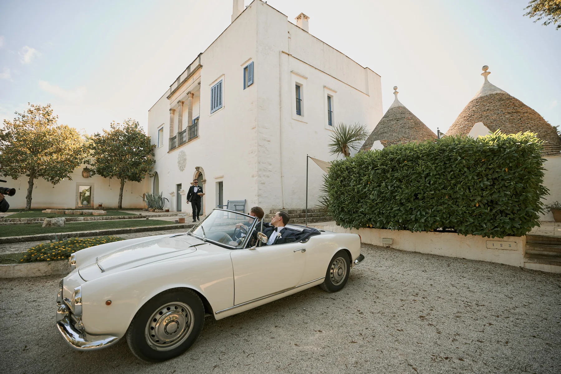 L’auto d’epoca davanti alla villa bianca e ai trulli