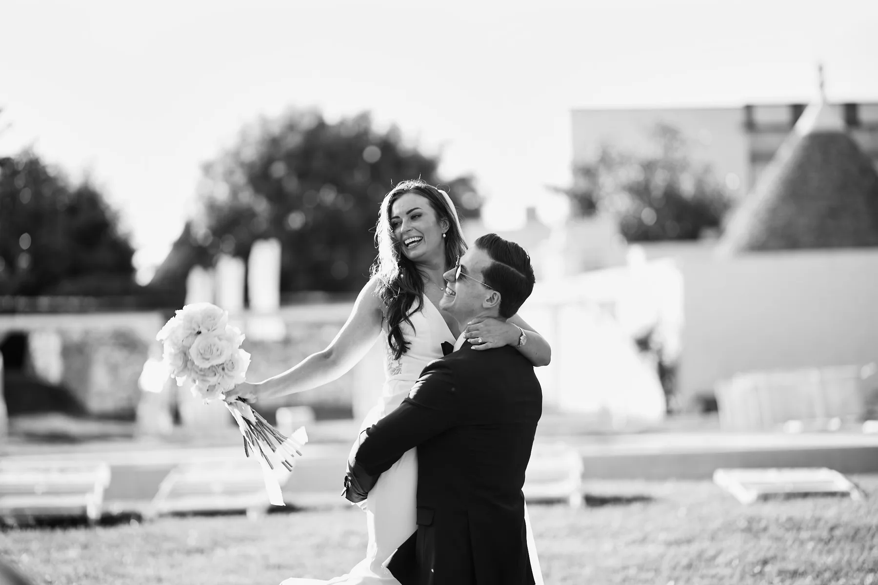 Lo sposo solleva la sposa in un abbraccio, in bianco e nero
