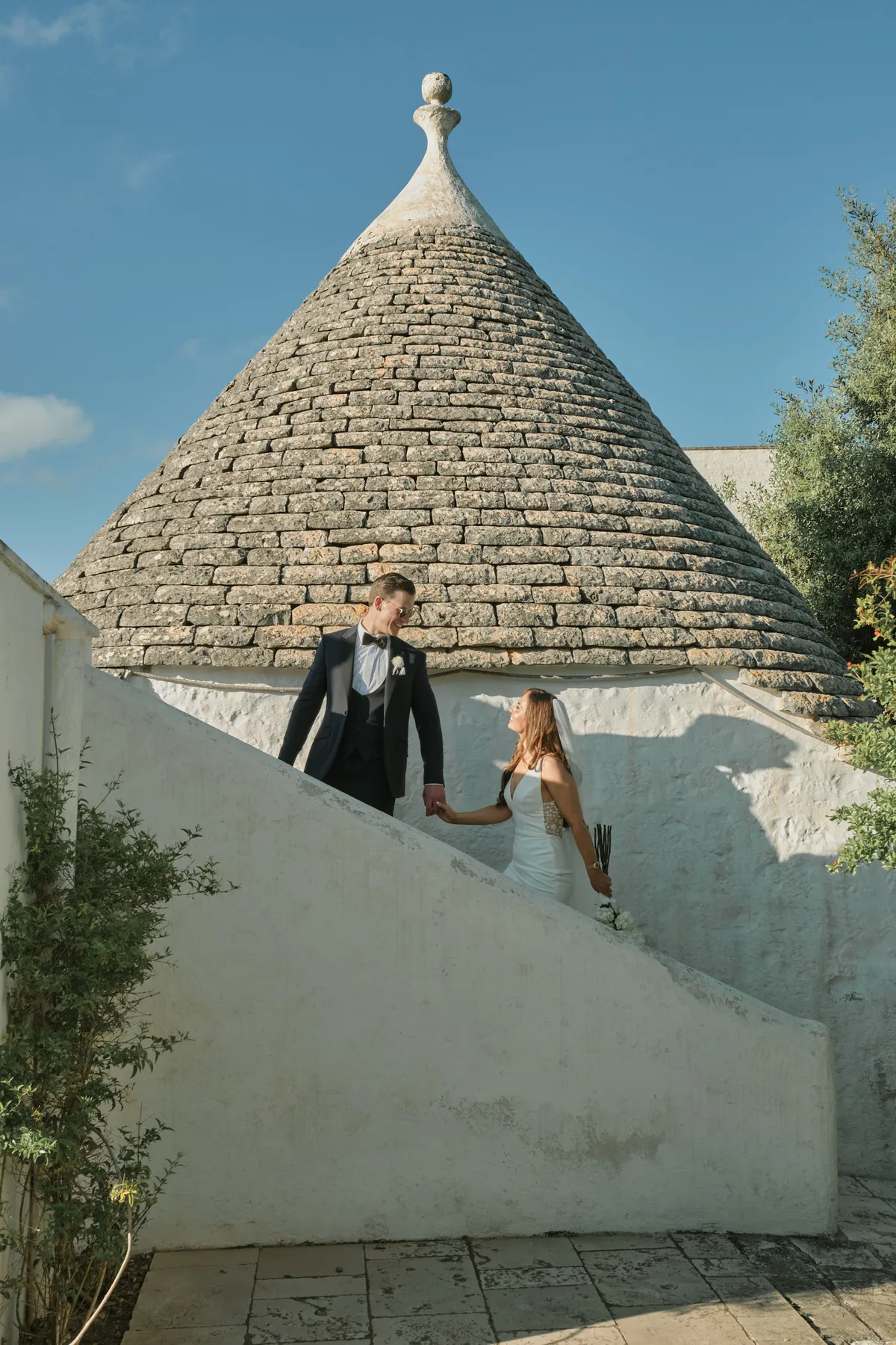 Gli sposi sulle scale di un trullo