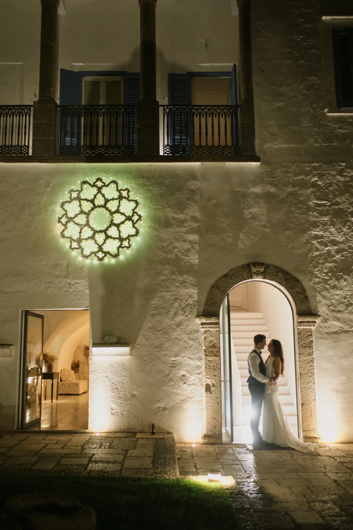 Gli sposi sotto un arco in pietra illuminato, di notte
