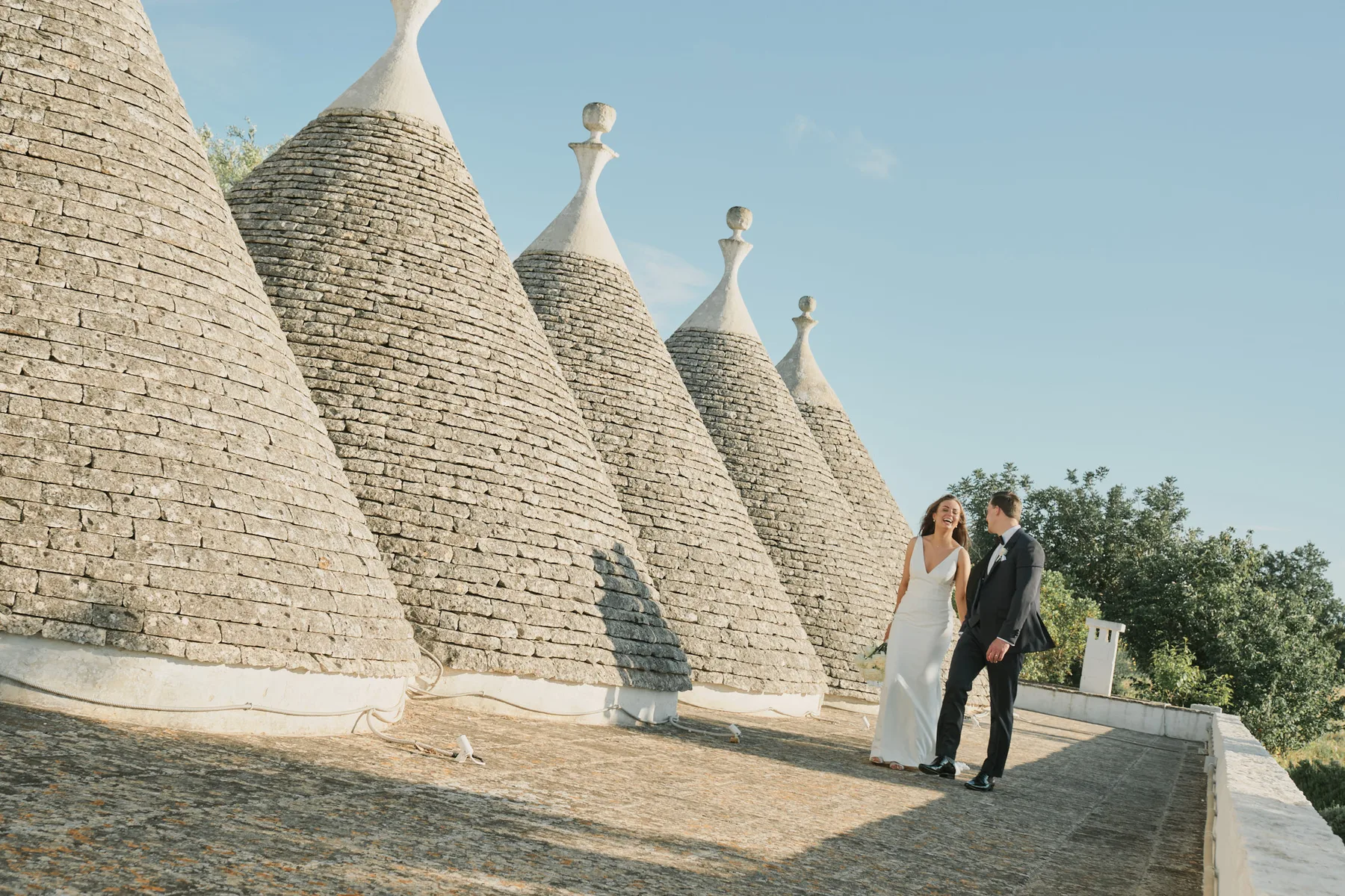 Sarah and Lewis beside the stone cones of the trulli at Villa Cenci, Cisternino