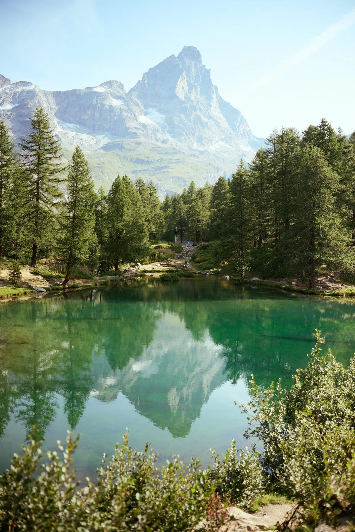 Un lago di montagna che riflette le vette circostanti