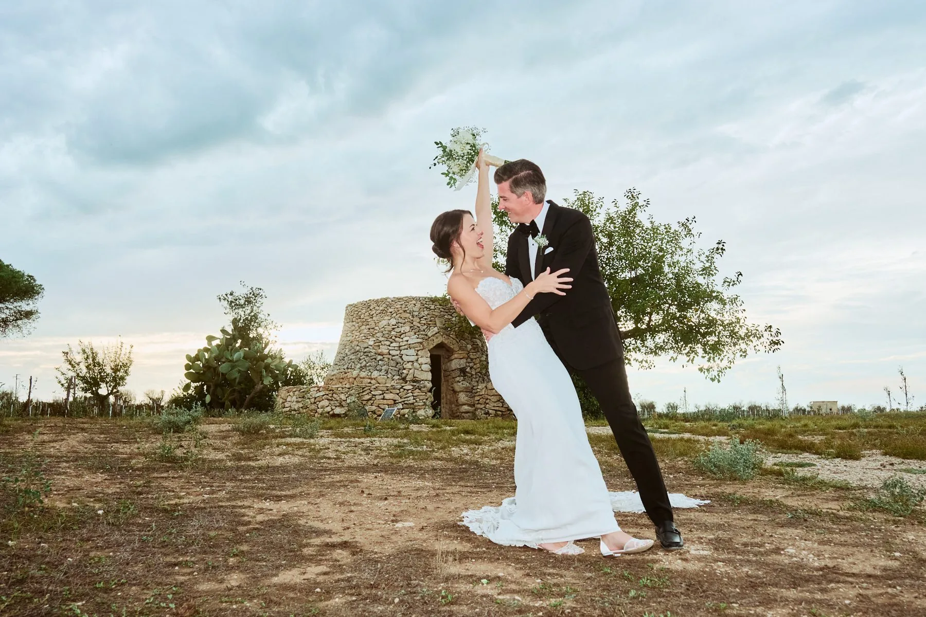 Portrait of the couple at dusk under a stone archway