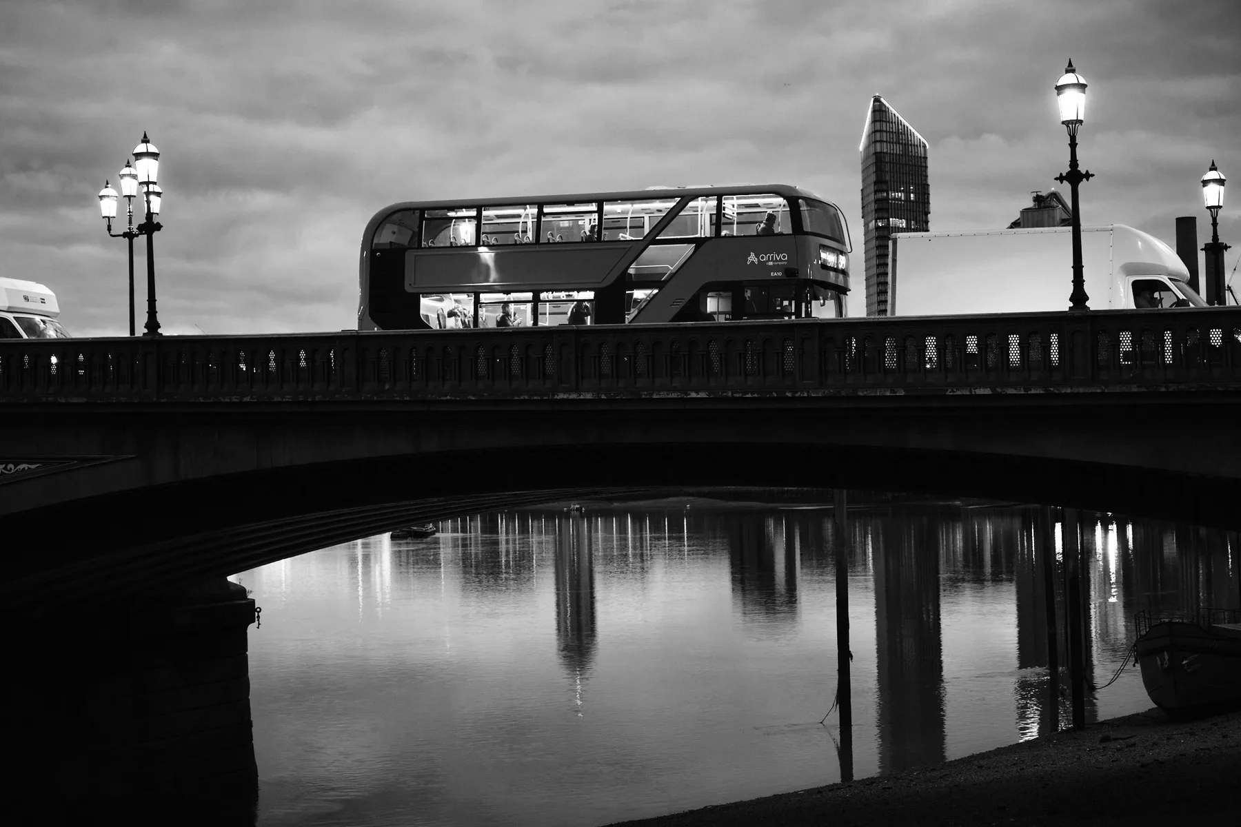 Un autobus a due piani attraversa il ponte al tramonto