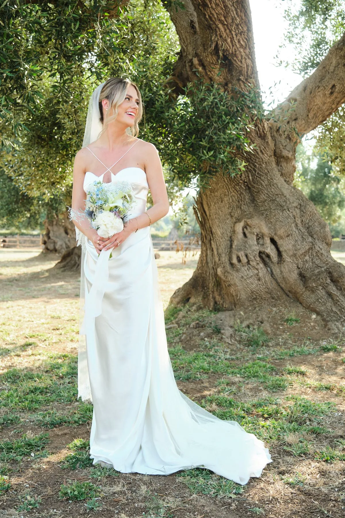 Ritratto di Lydia accanto a un ulivo secolare, con il bouquet in mano