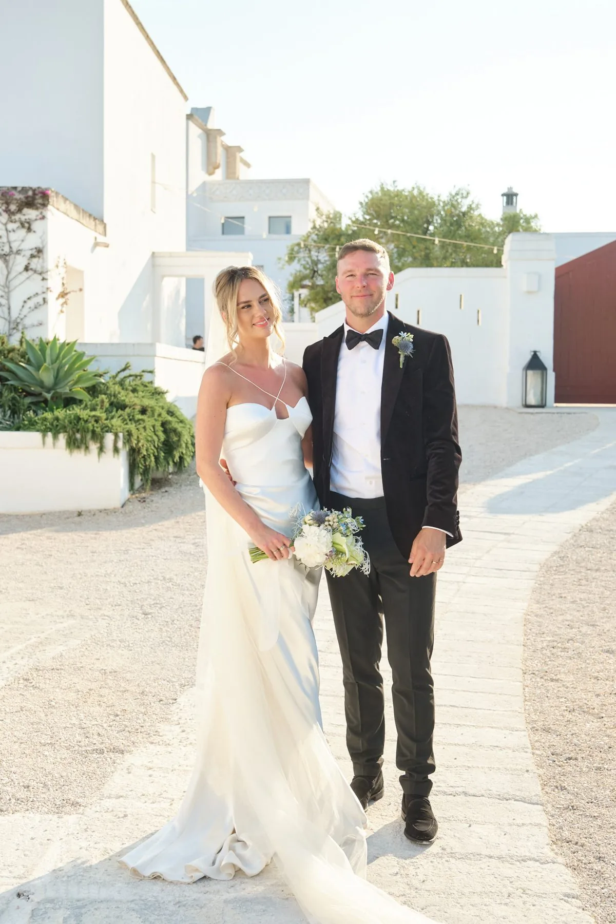 Lydia e Sam camminano insieme negli spazi esterni della masseria
