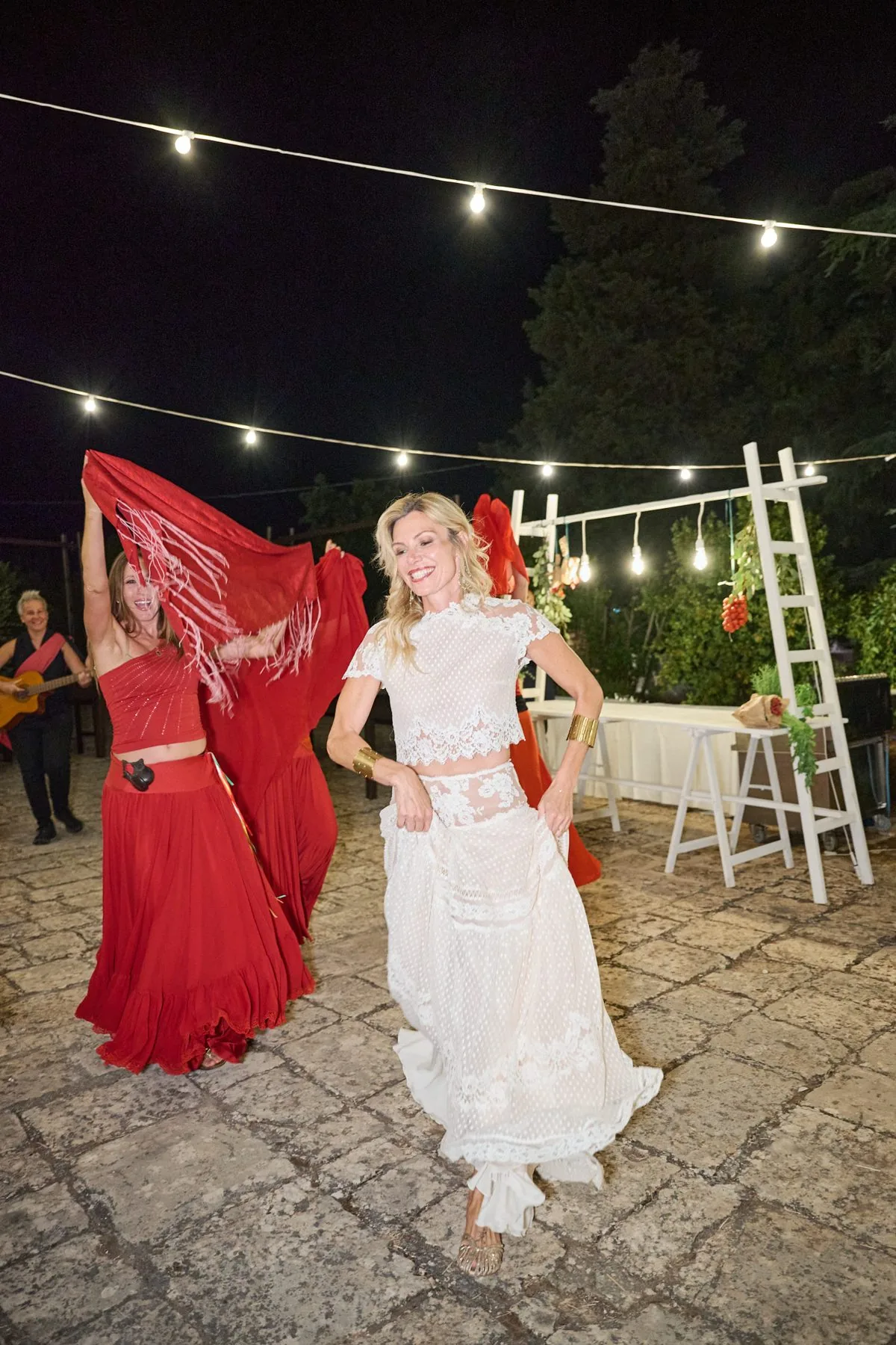Solen balla la pizzica con un foulard rosso, sotto le luci sospese