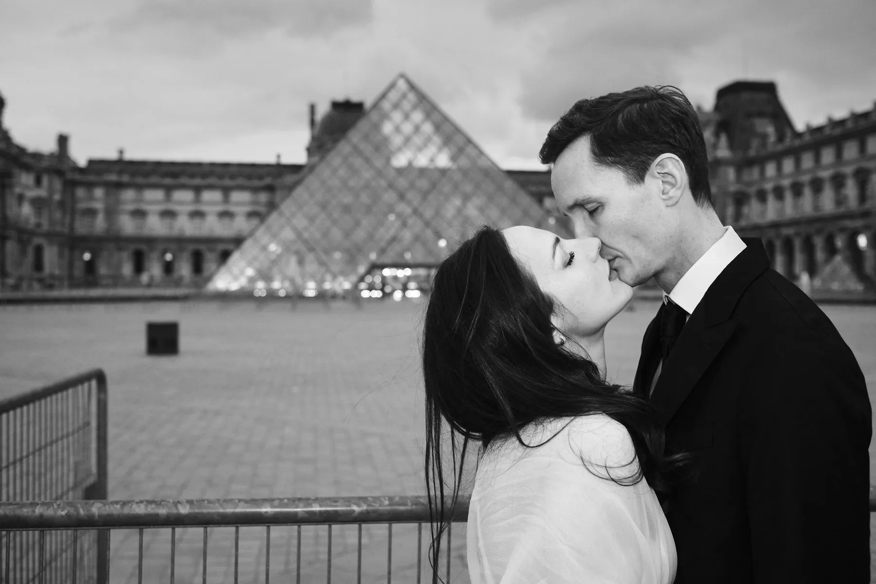 Il bacio di Vincent e Francesca davanti alla piramide del Louvre