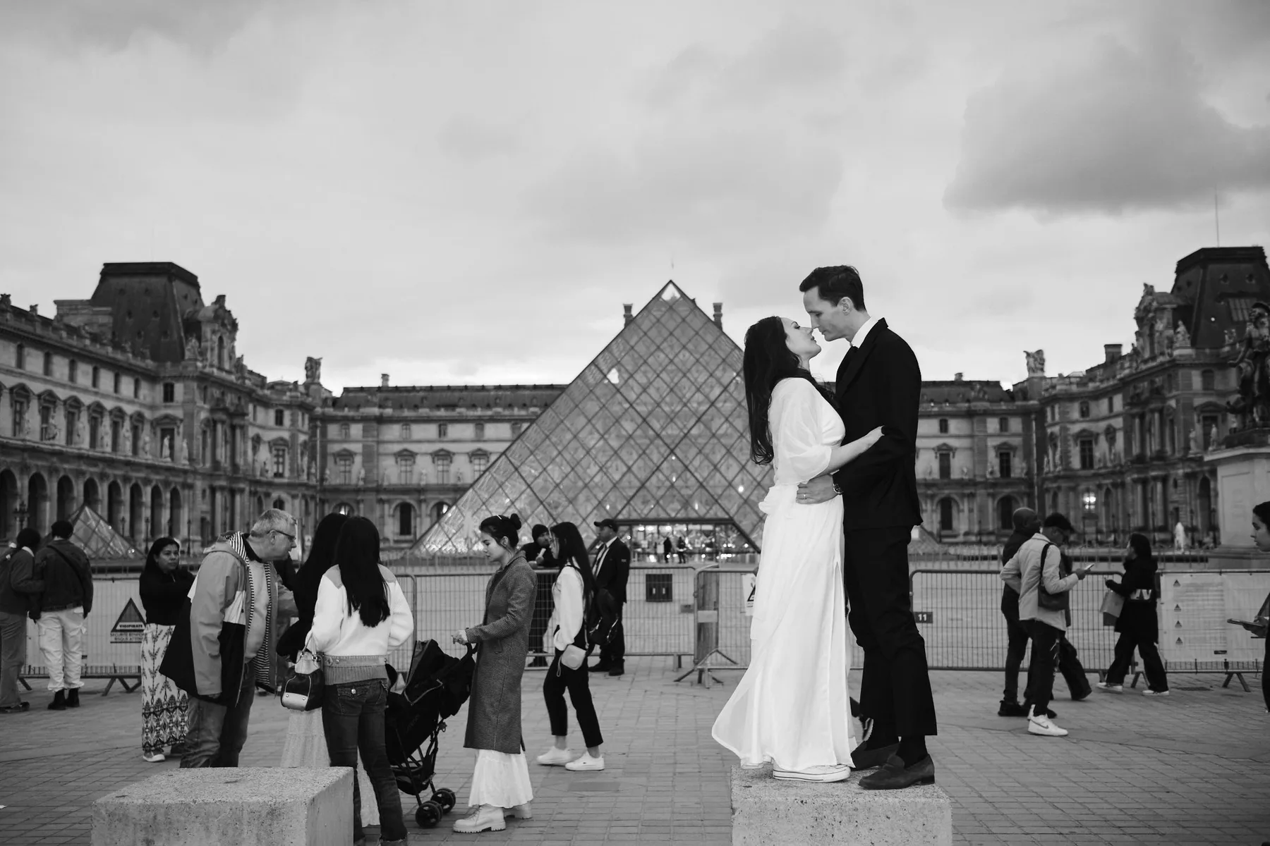 Gli sposi davanti alla piramide del Louvre, tra i passanti