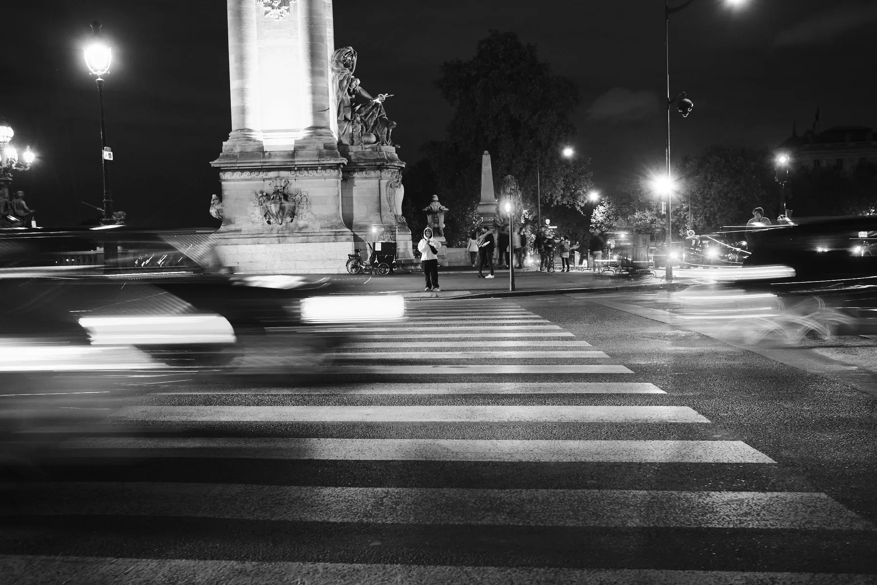 Le auto sfrecciano accanto alle colonne del Pont Alexandre III